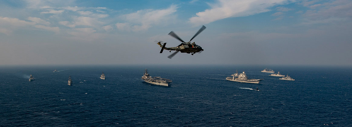 NORTH ARABIAN SEA (Nov. 17, 2020) - An MH-60S Sea Hawk helicopter, from the “Screamin’ Indians” of Helicopter Sea Combat Squadron (HSC) 6, flies over ships from the Indian Navy, Japan Maritime Self-Defense Force (JMSDF), the Royal Australian Navy and the U.S. Navy as they sail in formation, Nov. 17, 2020, in the North Arabian Sea as part of Exercise Malabar 2020. Malabar 2020 is the latest in a continuing series of exercises that has grown in scope and complexity over the years to address the variety of shared threats to maritime security in the Indo-Asia Pacific where the U.S. Navy has patrolled for more than 70 years promoting regional peace and security. Nimitz Carrier Strike Group is currently deployed to the 7th Fleet area of operations in support of a free and open Indo-Pacific. 