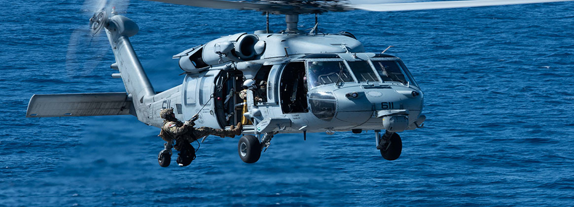 PHILIPPINE SEA (Sept. 21, 2022) - A member of Explosive Ordnance Disposal Mobile Unit (EODMU) 5, attached to Commander, Task Force (CTF) 70, begins to descend from an MH-60S Seahawk, attached to the Golden Falcons of Helicopter Sea Combat Squadron (HSC) 12, during a helicopter rope suspension technique (HRST) exercise on the flight deck of the U.S. Navy’s only forward-deployed aircraft carrier, USS Ronald Reagan (CVN 76), in the Philippine Sea, Sept. 21. Ronald Reagan, the flagship of Carrier Strike Group 5, provides a combat-ready force that protects and defends the United States, and supports alliances, partnerships and collective maritime interests in the Indo-Pacific region. 